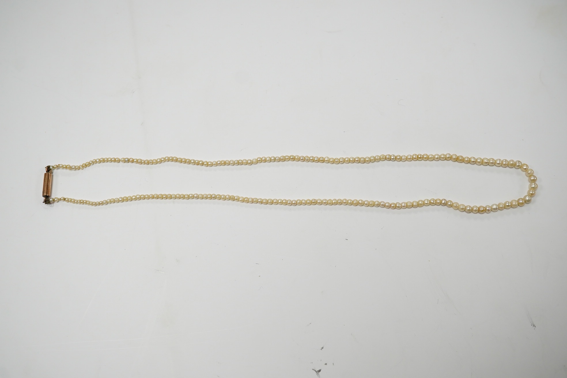 An early 20th century single strand graduated seed pearl necklace, with 9ct barrel clasp, 38cm. Condition - fair